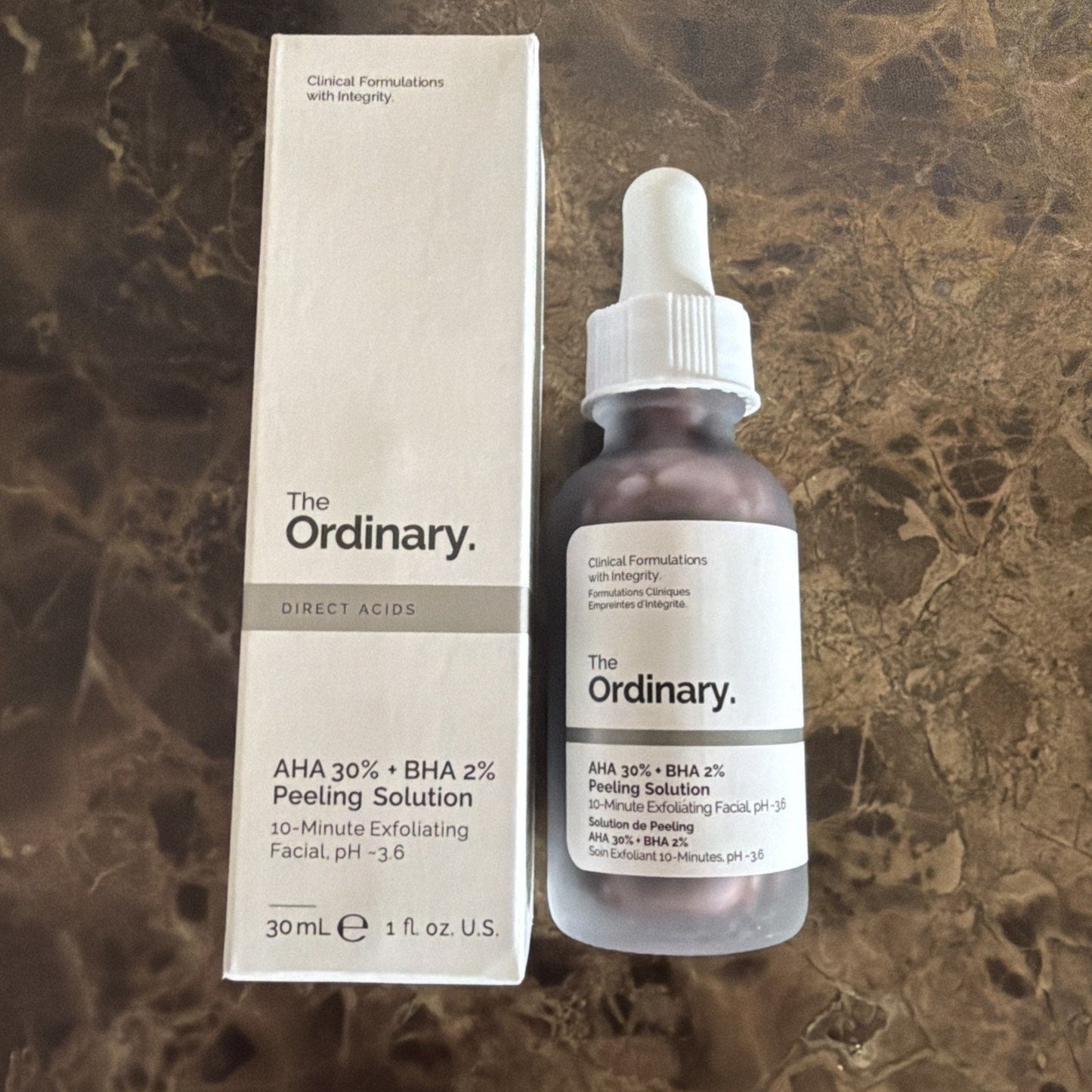 The Ordinary AHA 30% + BHA 2% Peeling Solution frosted glass bottle with dropper cap beside its white box