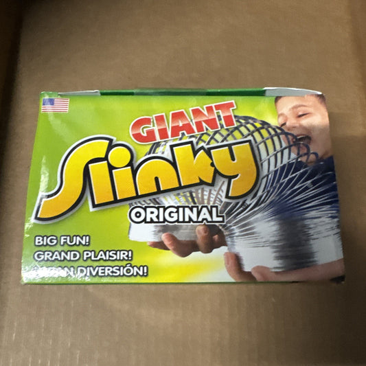 The Original Giant Slinky box showing colorful metal spring toy with hands holding and child playing background