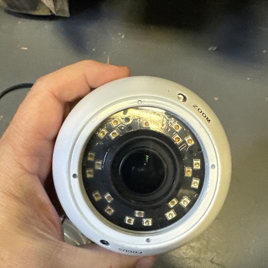 Hand holding white SHIELD analog CCTV dome security camera with visible lens and infrared LEDs around it