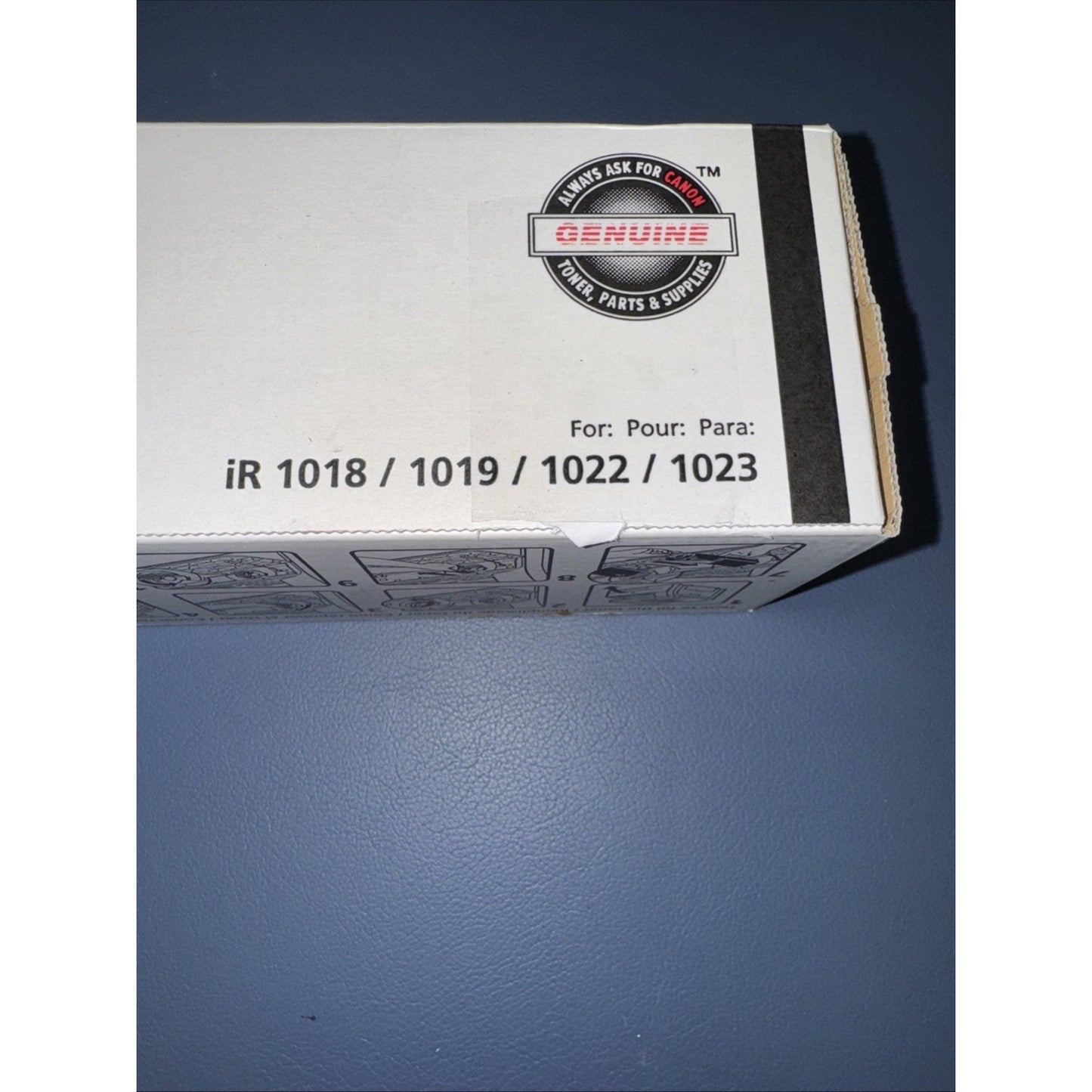 Close-up of a white product box corner showing compatibility with models iR 1018, 1019, 1022, and 1023, and a round sticker labeled "Genuine toner parts and supplies