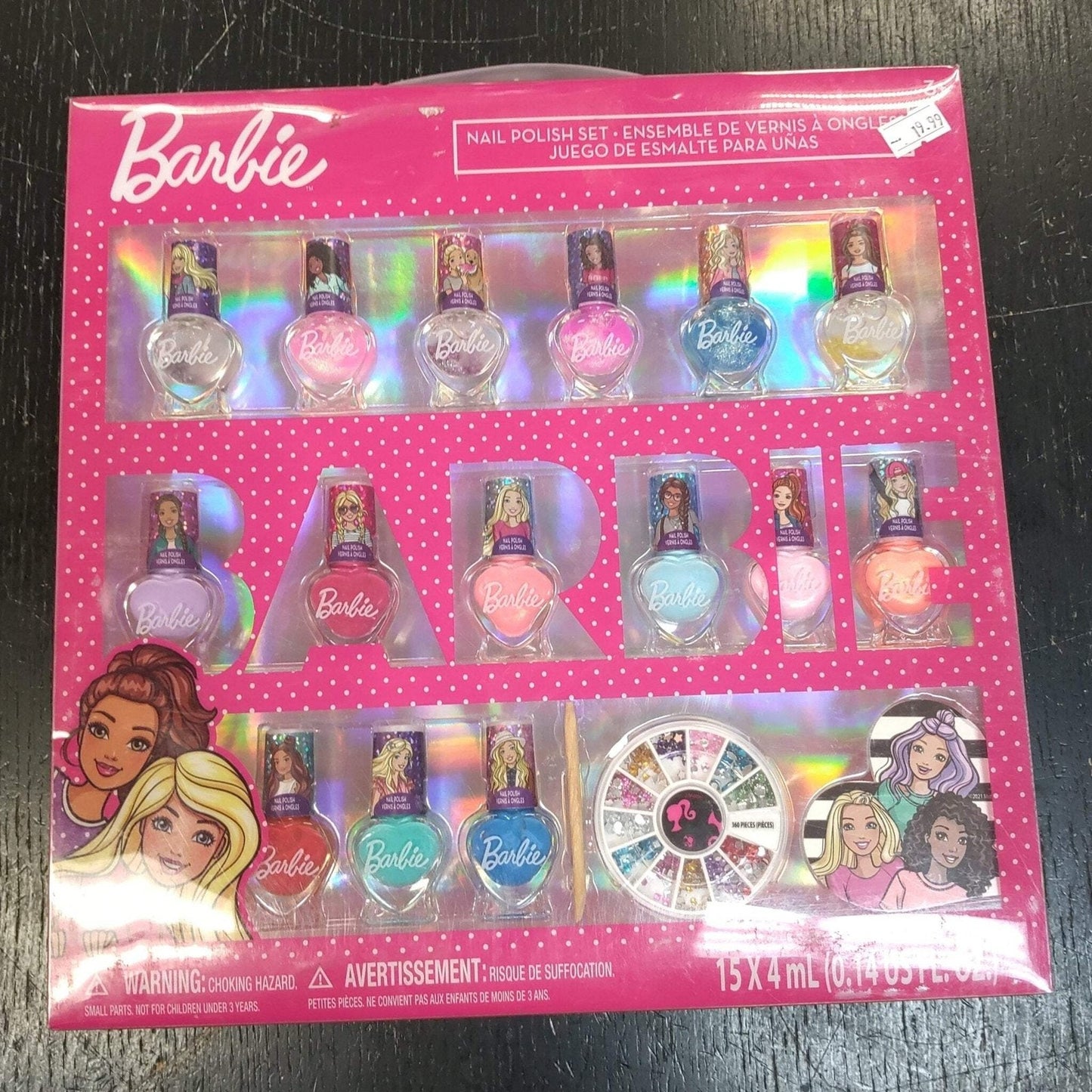 Set of 15 Barbie-themed nail polish bottles in various colors displayed in bright pink packaging with holographic accents and included nail art decorations.