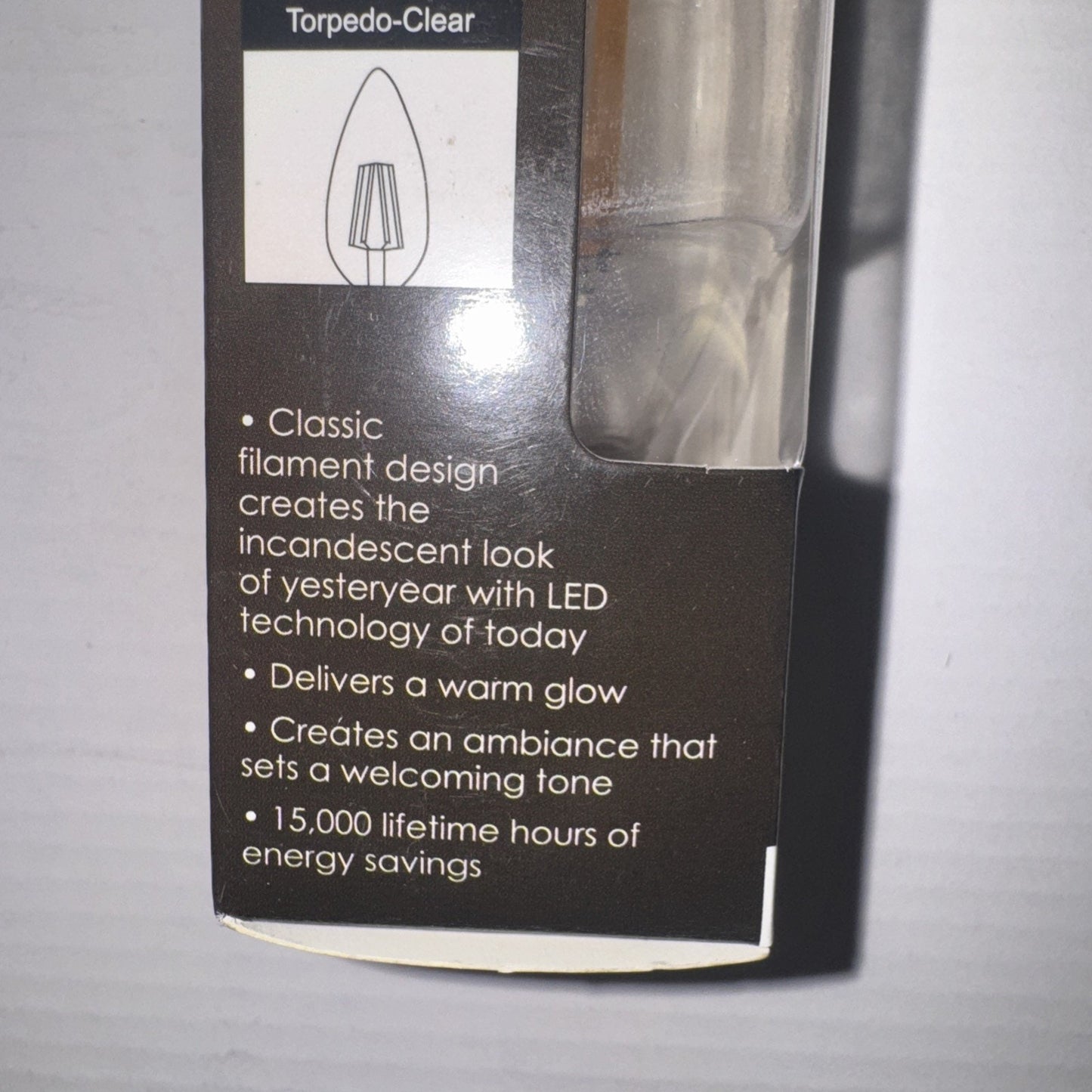Sunlite LED bulb package showing torpedo clear filament design and warm glow energy savings features on label side