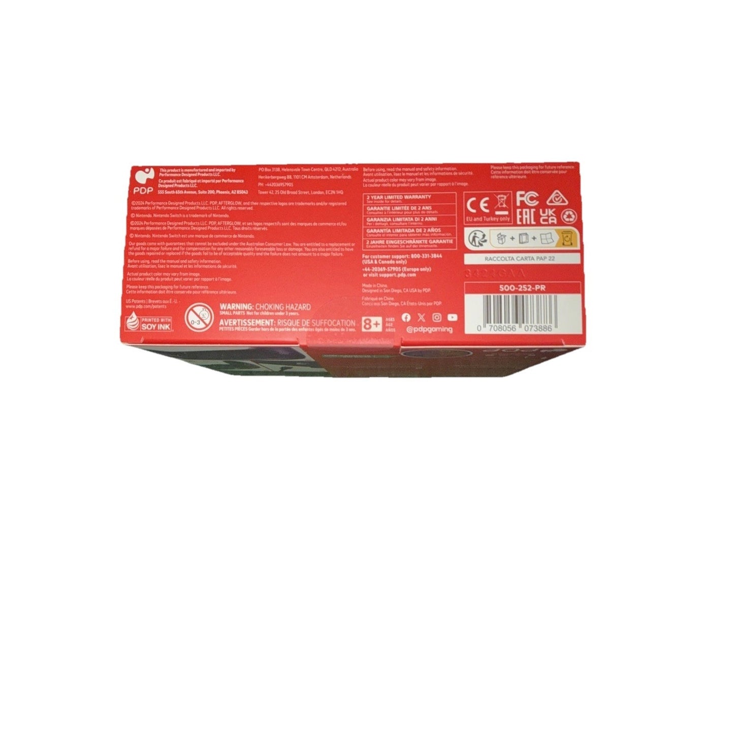 Red product packaging box showing manufacturing details, safety warnings, certification logos including CE and FCC, barcode label, and age recommendation printed on the back panel.