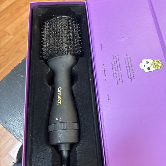 Amika Hair Blow Dryer Brush in black with gold logo, displayed in purple branded packaging box