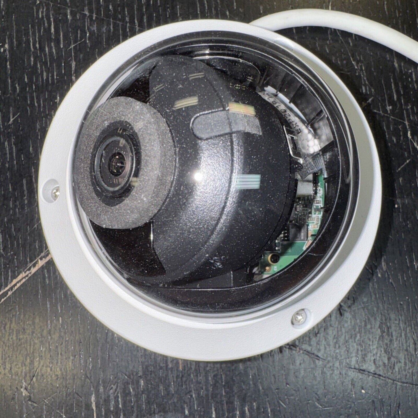 Hikvision DS-2CD1143G0-IS dome network camera with 4MP resolution and visible internal components on black surface