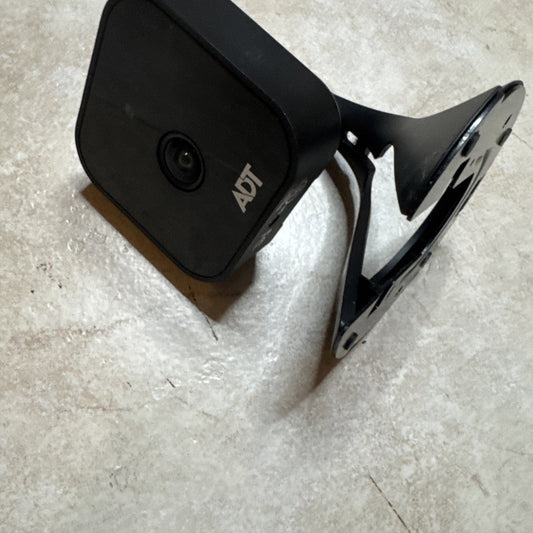 ADT Wireless Network Camera 720P HD model RC8326 in sleek black with adjustable mounting bracket on concrete surface