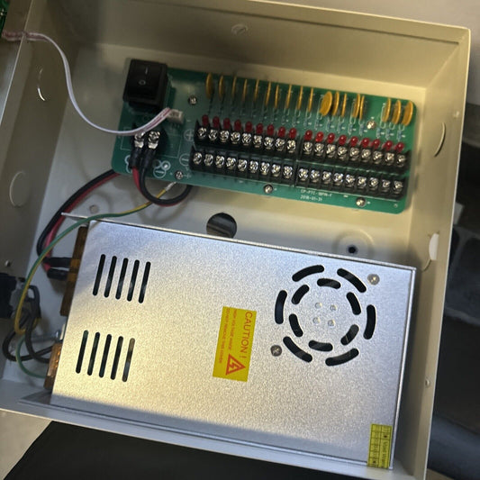 18 channel power supply unit for camera system with metal casing and multiple output terminals inside beige enclosure