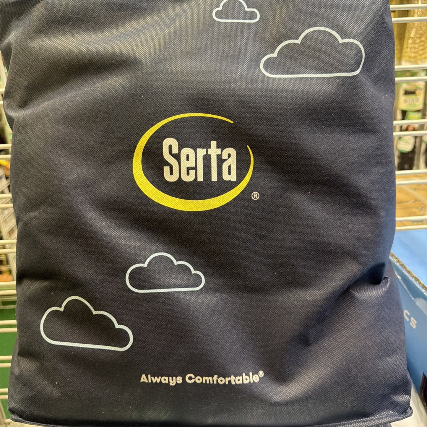 Black fabric bag featuring the Serta logo in yellow and white with simple white cloud illustrations and the tagline "Always Comfortable" printed at the bottom.