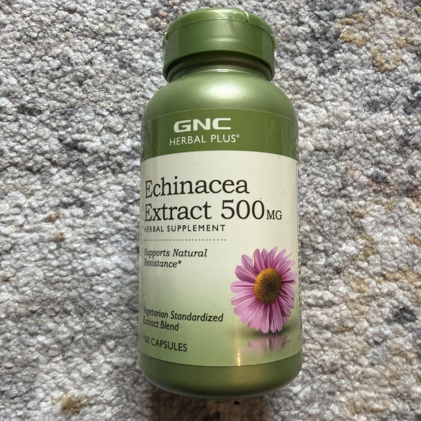 Green plastic bottle of GNC Herbal Plus Echinacea Extract 500 mg supplement, featuring a pink coneflower image and labeled as a vegetarian standardized extract blend with 100 capsules.