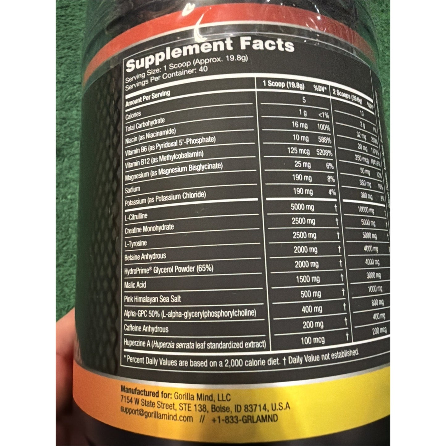 Close-up of a dietary supplement label showing detailed nutritional information and ingredient amounts per serving, with company contact details at the bottom.