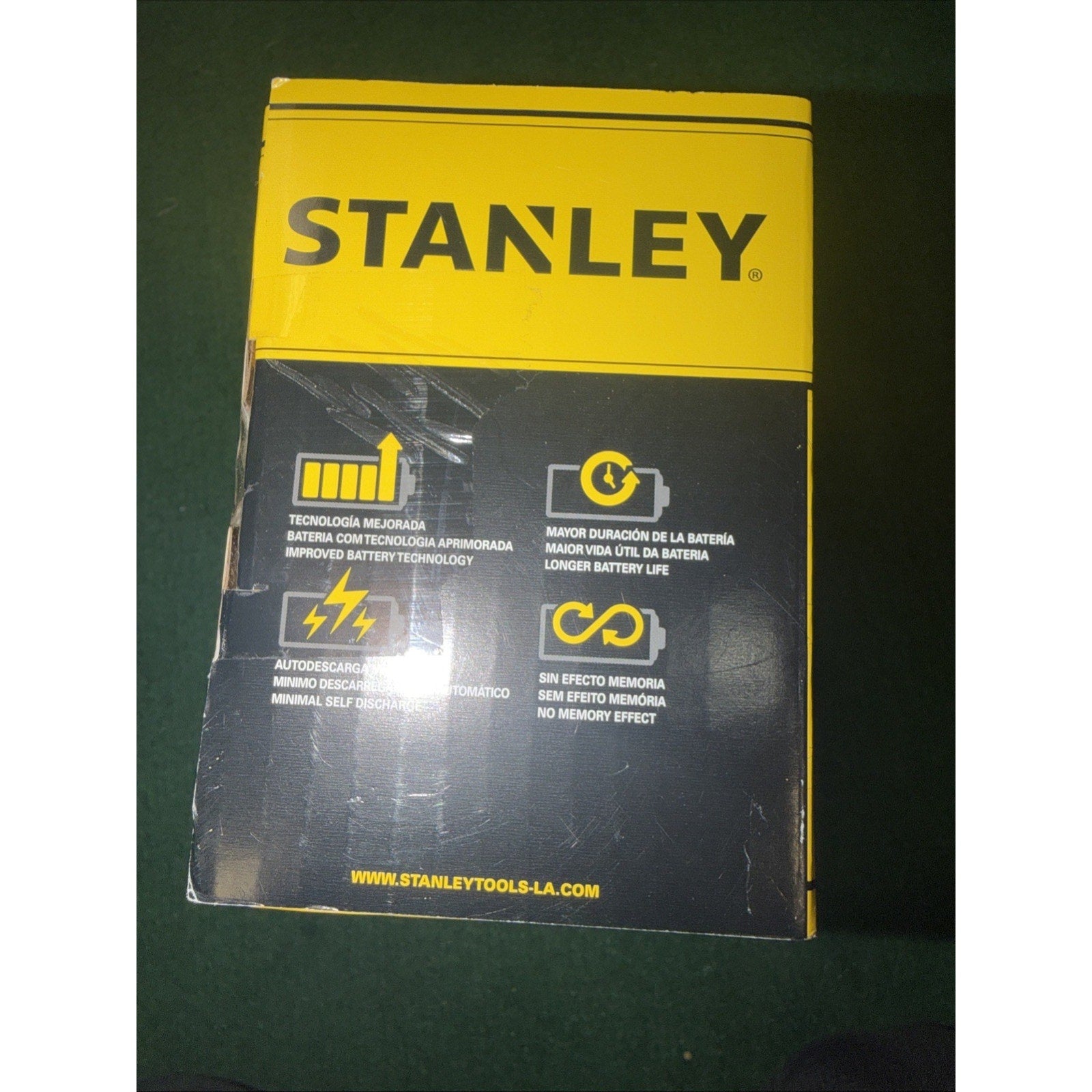 Yellow and black Stanley product packaging highlighting features including improved battery technology, longer battery life, manual self-discharge, and no memory effect, with website URL at the bottom.