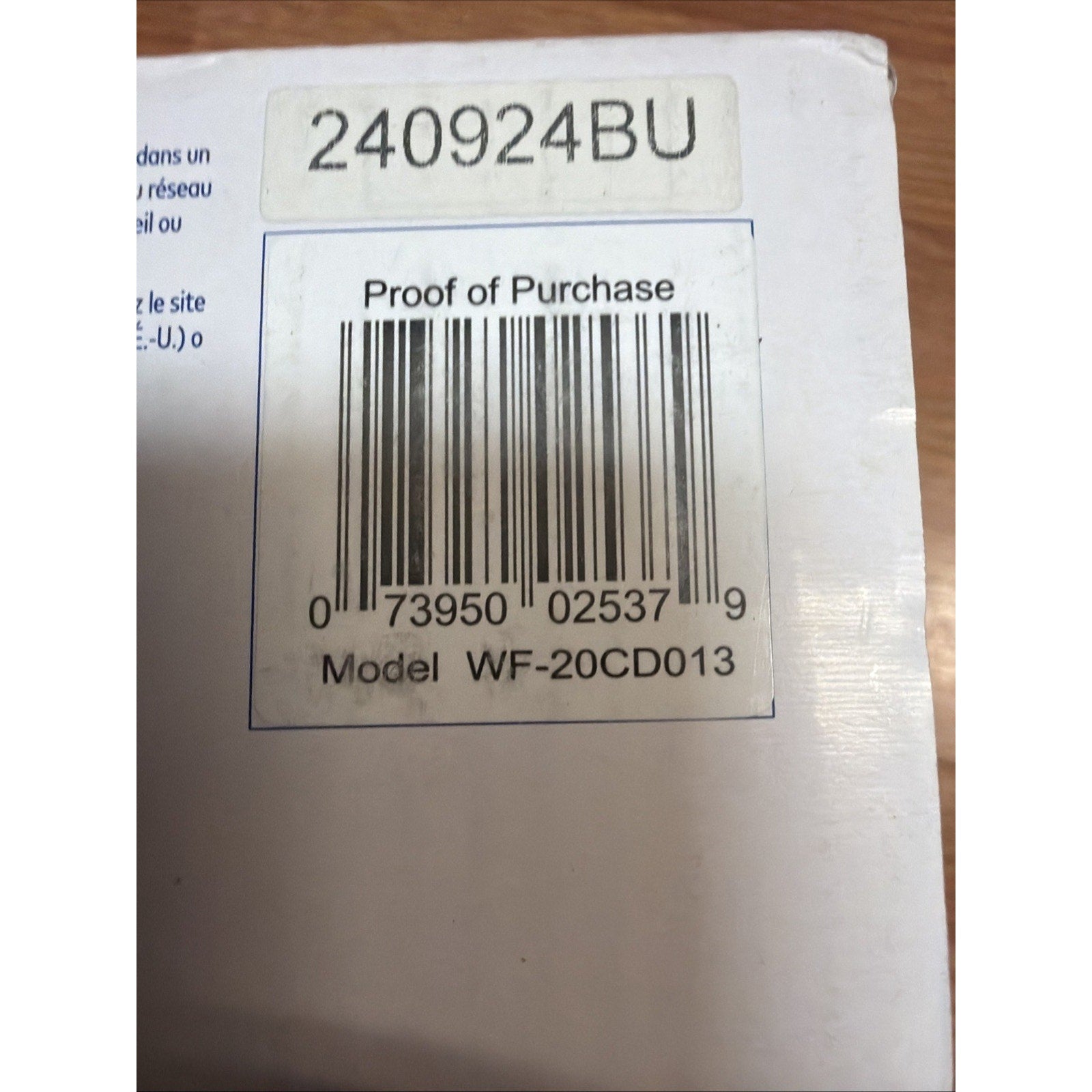 Close-up of a white product box corner featuring a barcode with the label "Proof of Purchase," model number WF-20CD013, and a separate alphanumeric sticker reading 240924BU.