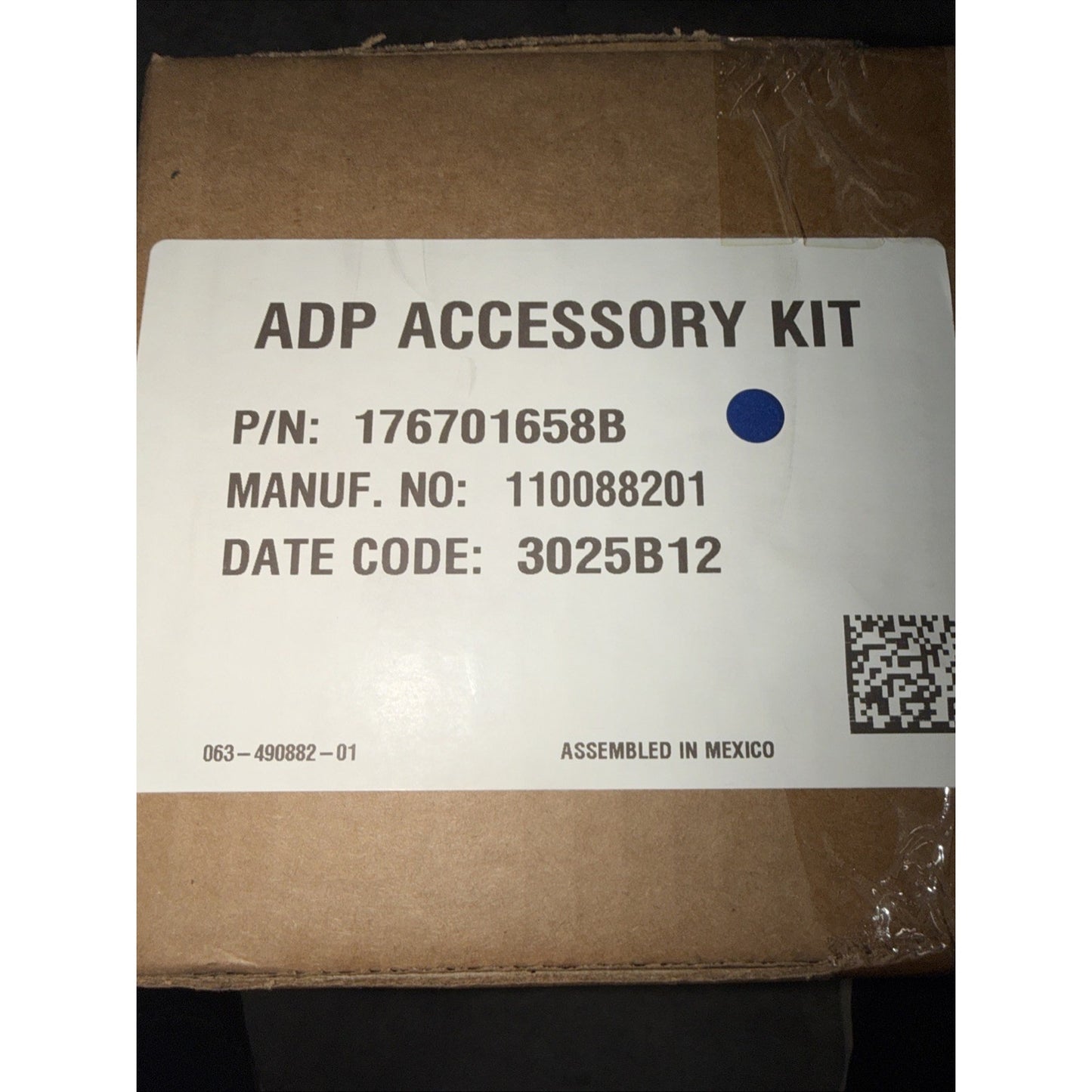 Brown cardboard box with a white label showing an ADP accessory kit part number, manufacturing number, date code, QR code, and "Assembled in Mexico" text.