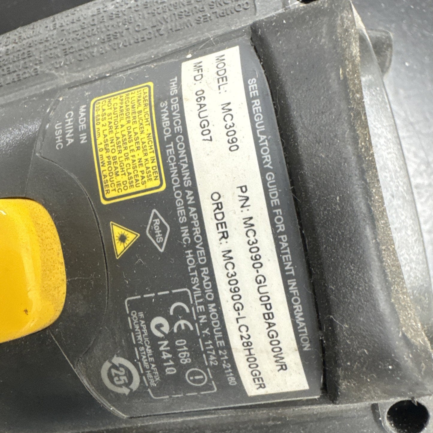 Close-up of Motorola Symbol MC3090 barcode scanner label with model number, serial, and certification details visible