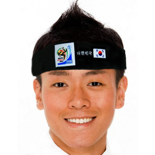 Smiling man wearing a black headband featuring the 2010 FIFA World Cup South Africa logo, the South Korean flag, and Korean text on a white background.