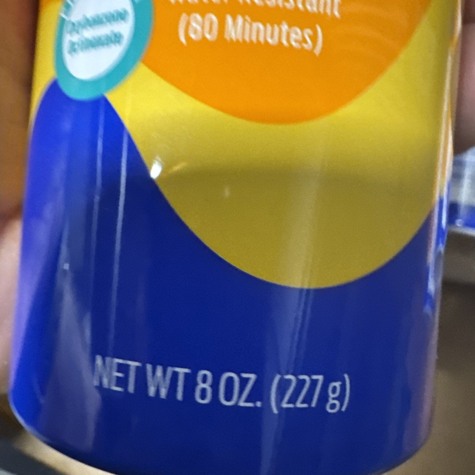 Close-up of Banana Boat Sport Ultra Sunscreen SPF 50 bottle showing net weight 8 oz (227 g) in blue and yellow packaging