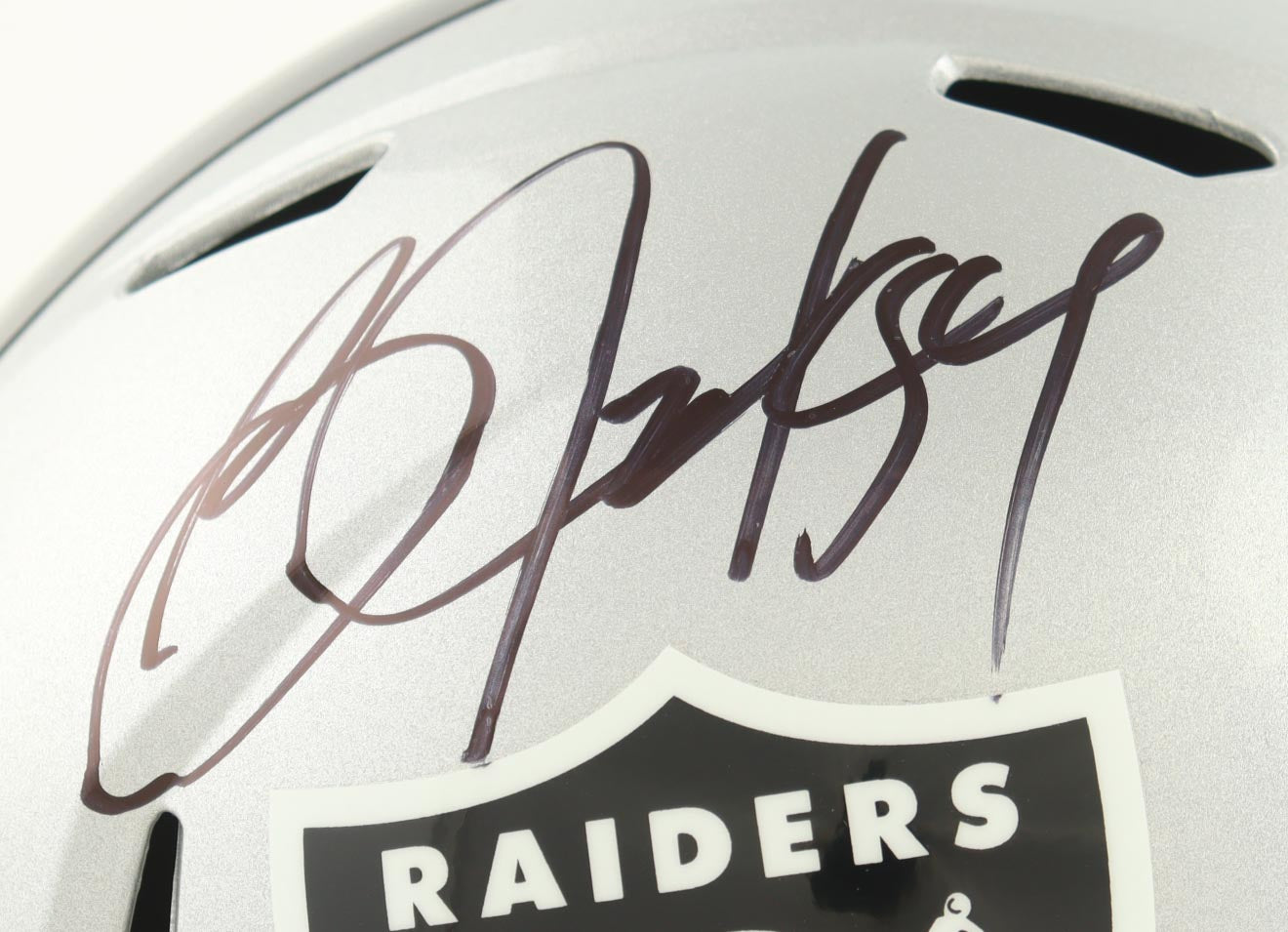 Close-up of Bo Jackson autograph on silver Las Vegas Raiders full-size Speed replica football helmet with team logo