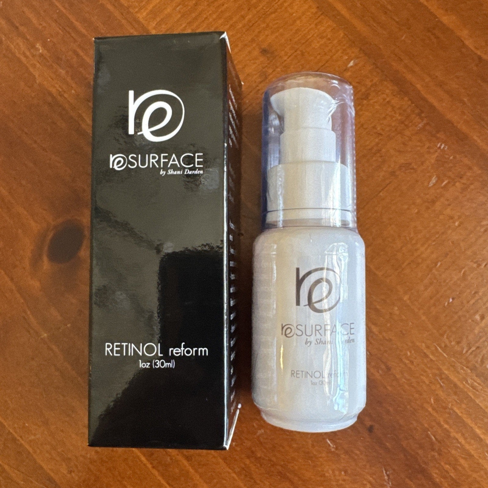 NEW SEALED BOX Resurface by Shani Darden Retinol Reform Peel 1 oz bottle with black packaging on wooden surface