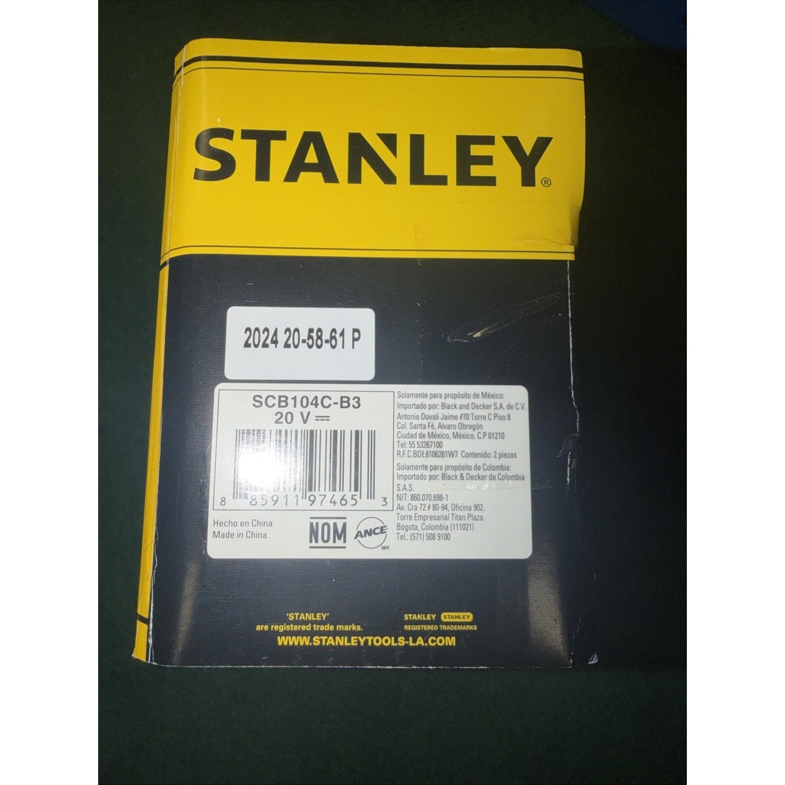 Yellow and black Stanley product packaging showing model number SCB104C-B3, 20V power rating, barcode, manufacturing details including Made in China, and regulatory certifications on the back panel.