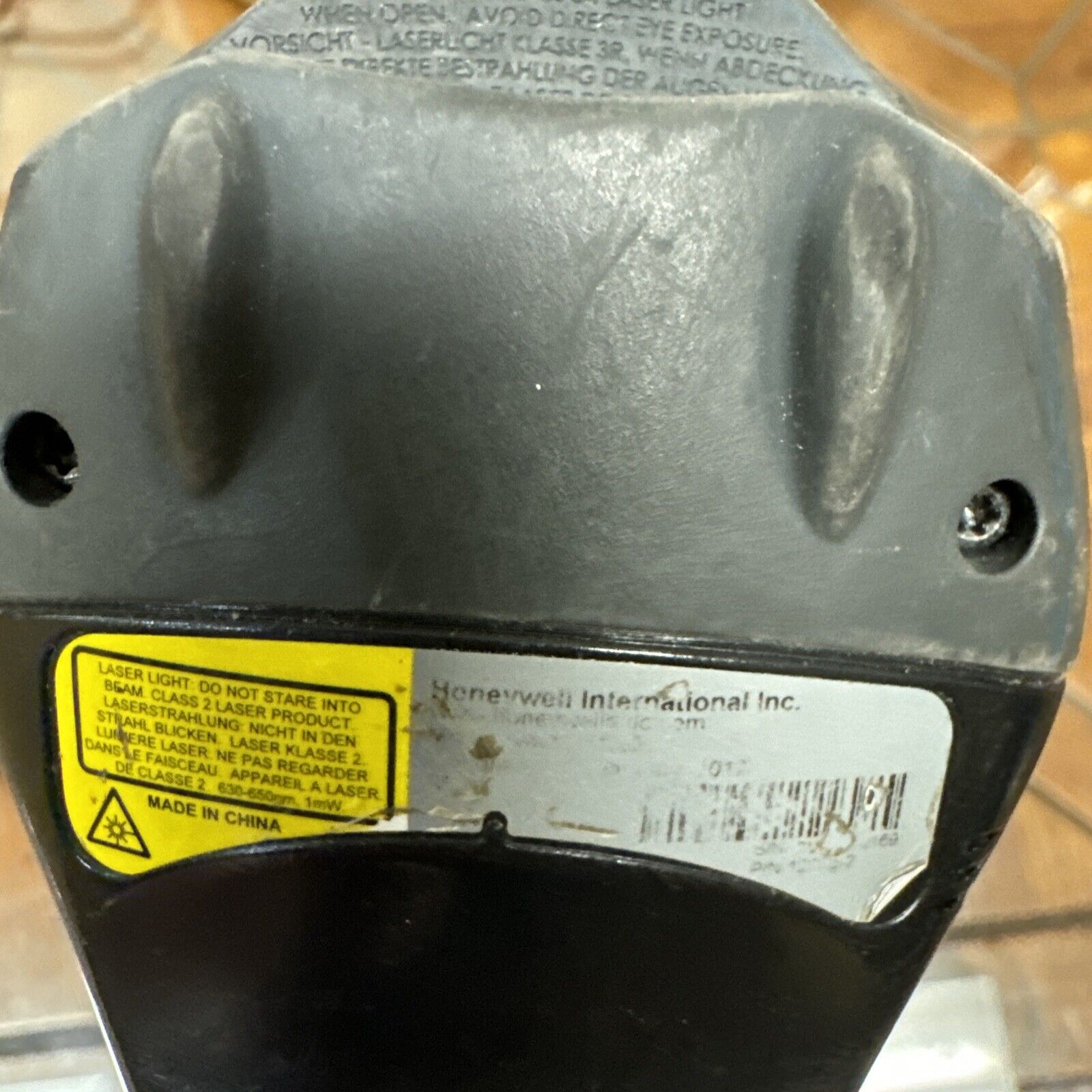 Used Honeywell International barcode scanner with worn label and warning sticker on back panel made in China
