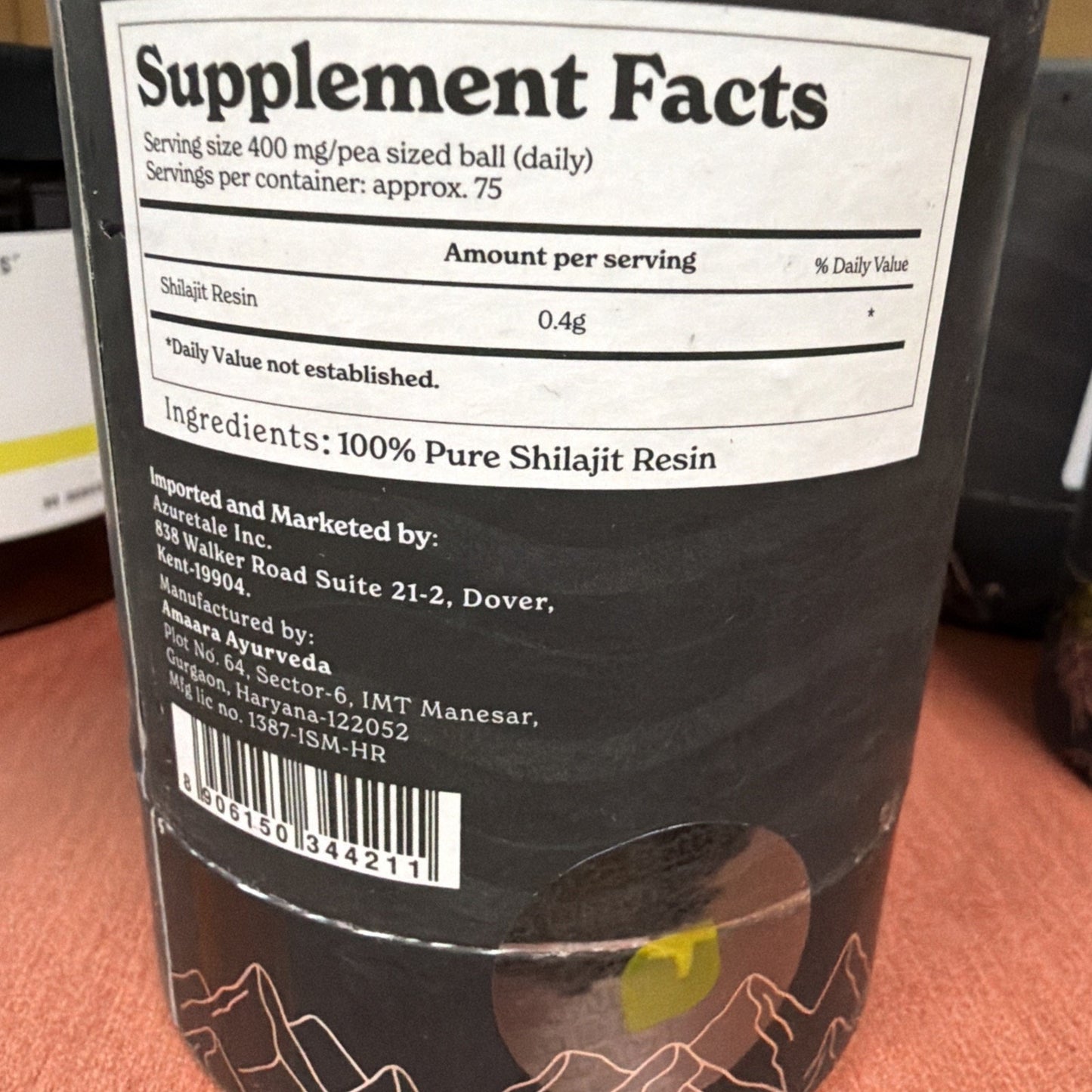Close-up of a supplement label showing serving size of 400 mg of Shilajit Resin per pea-sized ball with approximately 75 servings per container and 100% pure Shilajit Resin ingredient.