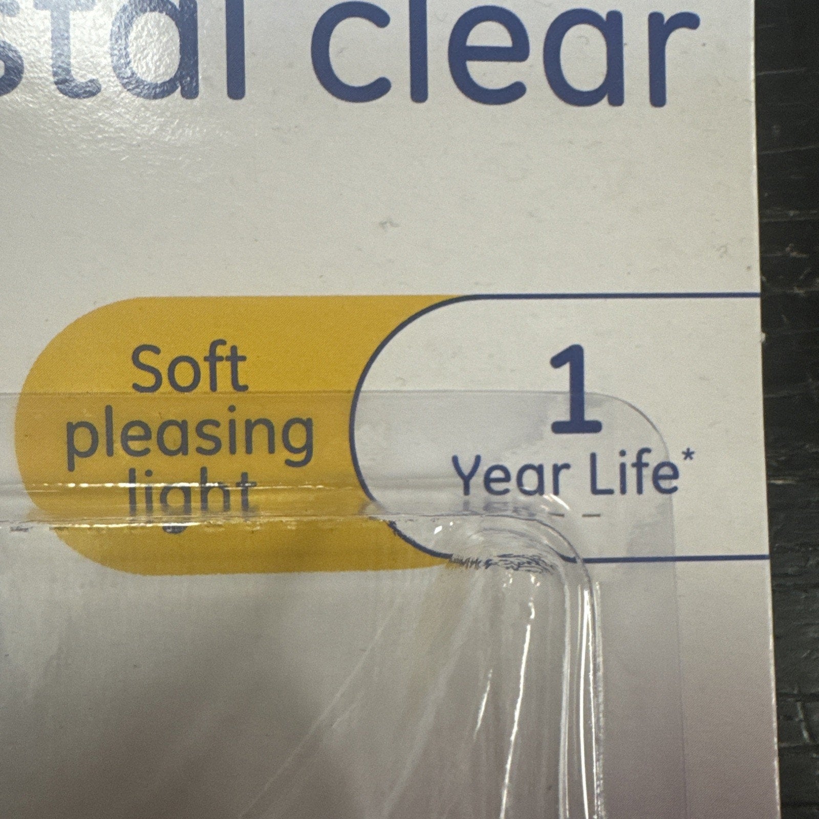 Packaging detail showing GE light bulb with soft pleasing light and one year life guarantee label