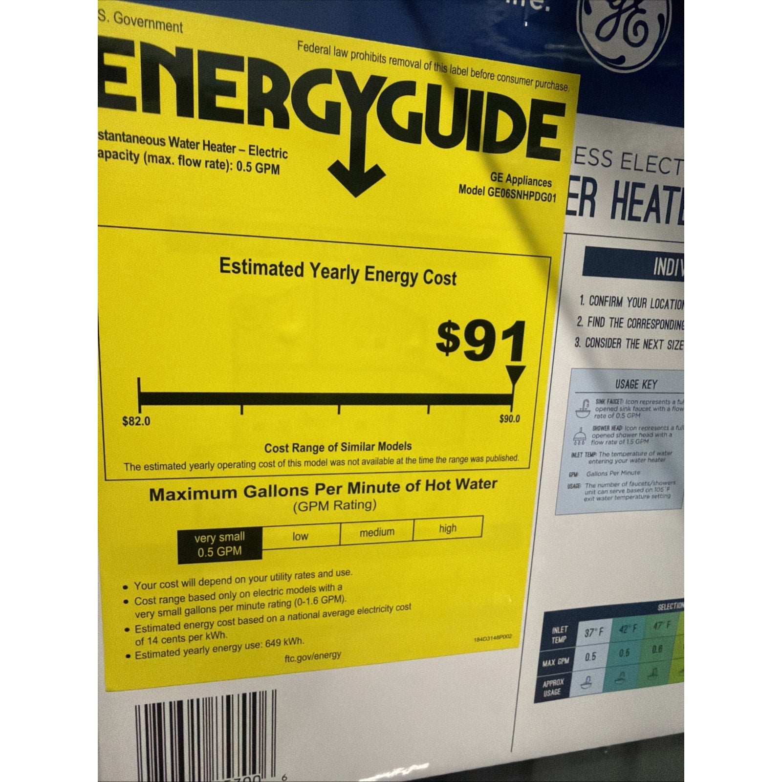 Yellow EnergyGuide label for an electric instantaneous water heater showing an estimated yearly energy cost of $91 and a maximum flow rate of 0.5 gallons per minute, with a barcode and additional usage instructions visible nearby.