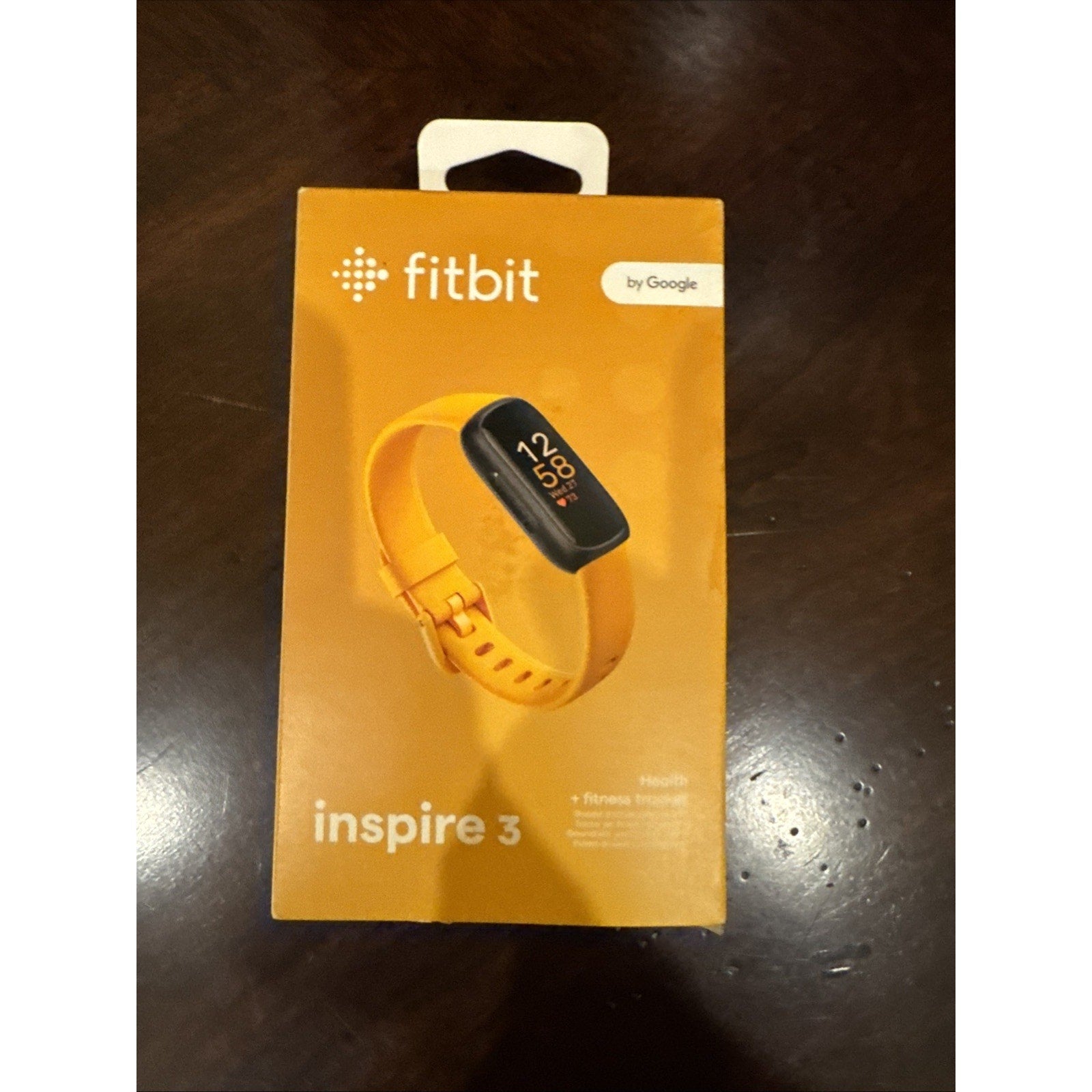 Fitbit Inspire 3 Health + Fitness Tracker in Morning Glow yellow color showing time and activity icons on screen