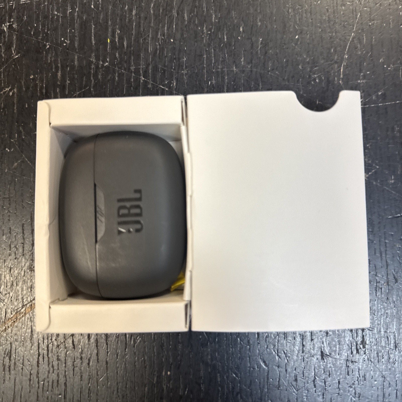 JBL Vibe Beam True Wireless Bluetooth Earbuds black charging case inside partially open white box viewed from above