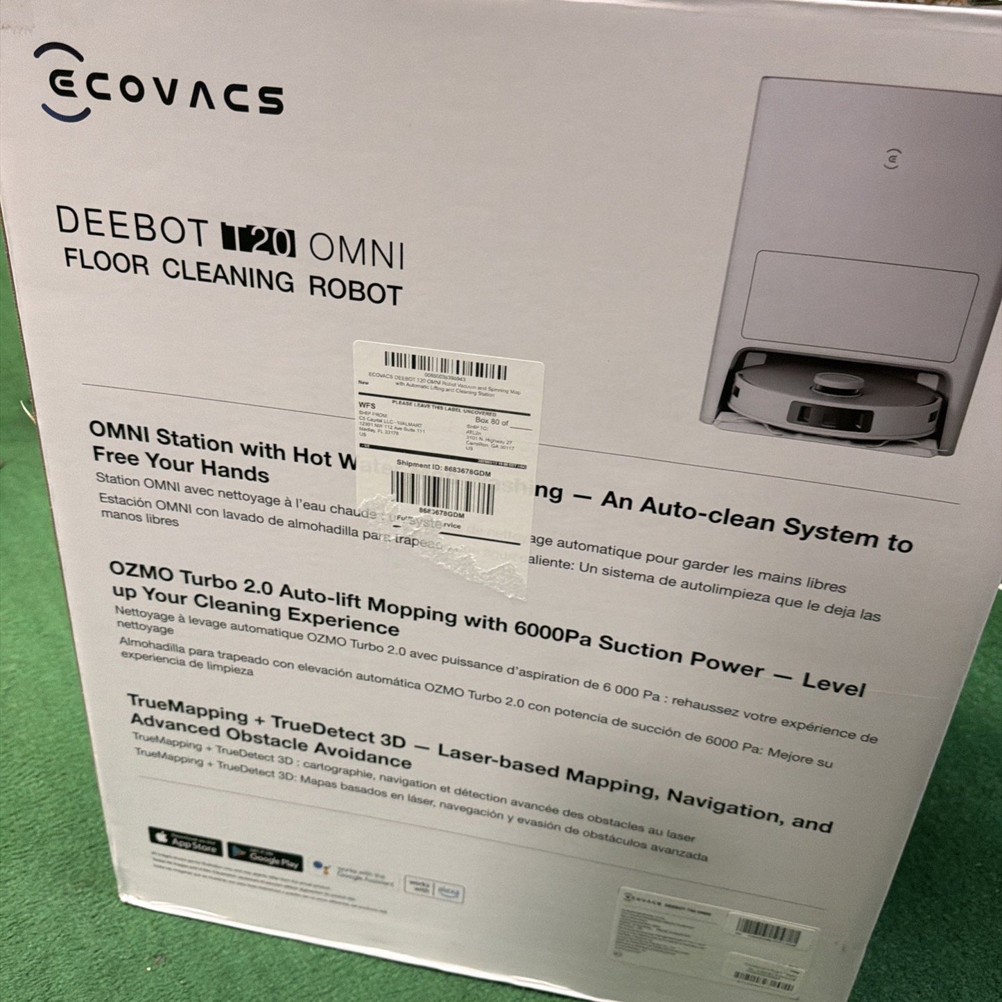 White retail box for Ecovacs DEEBOT OMNI floor cleaning robot displaying product features including OMNI Station with hot water washing, OZMO Turbo 2.0 auto-lift mopping, 6000Pa suction power, and advanced TrueMapping with 3D obstacle avoidance.