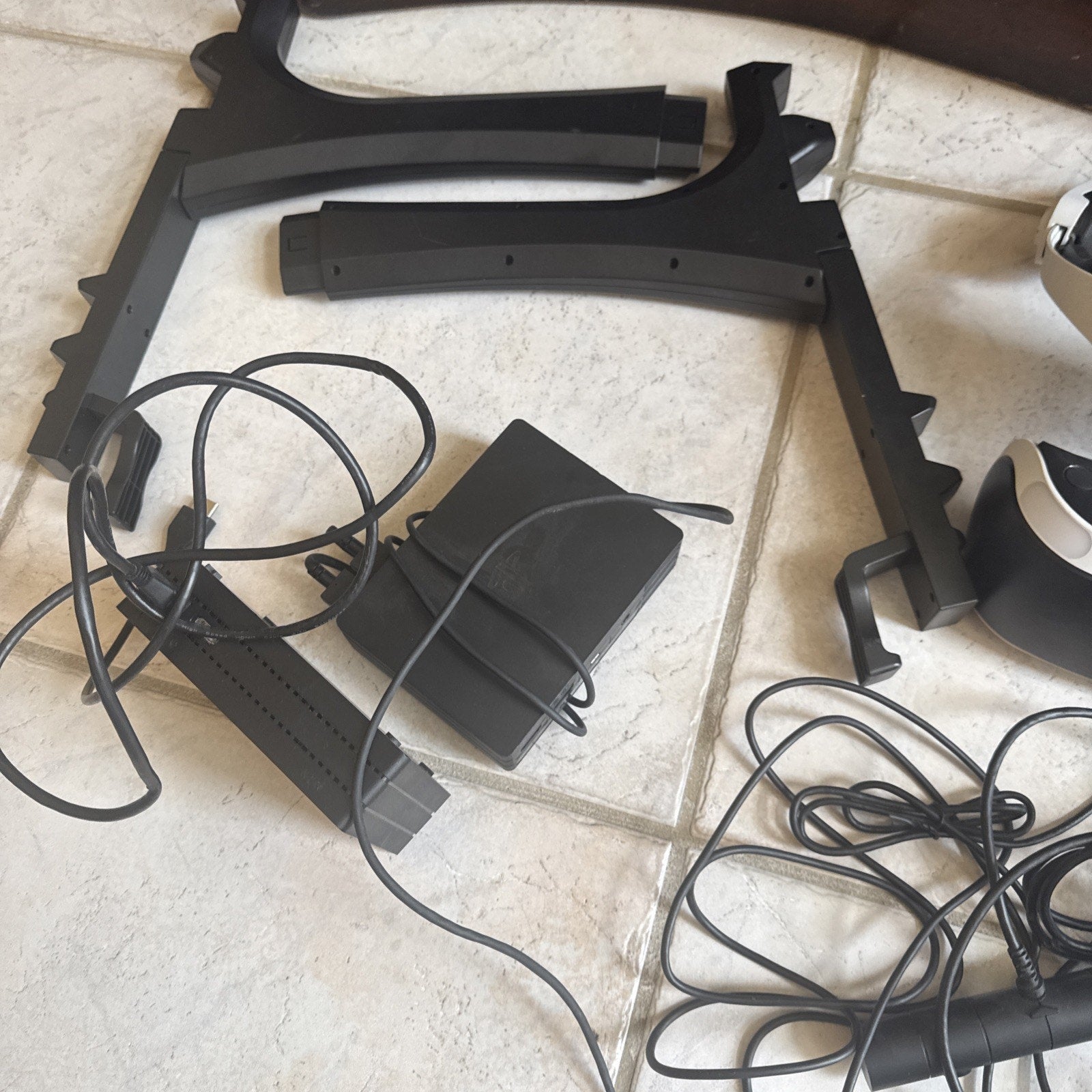 Two PlayStation VR sets with multiple accessories including cables, stands, and power adapters on tiled floor