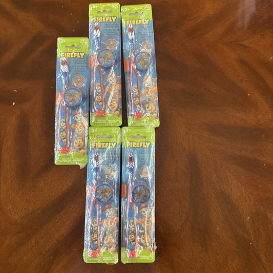 10-pack Firefly Nickelodeon Paw Patrol kids manual soft toothbrushes with caps in original packaging on wooden surface