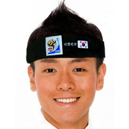 Smiling man wearing a black headband featuring the 2010 FIFA World Cup South Africa logo, the South Korean flag, and Korean text on a white background.