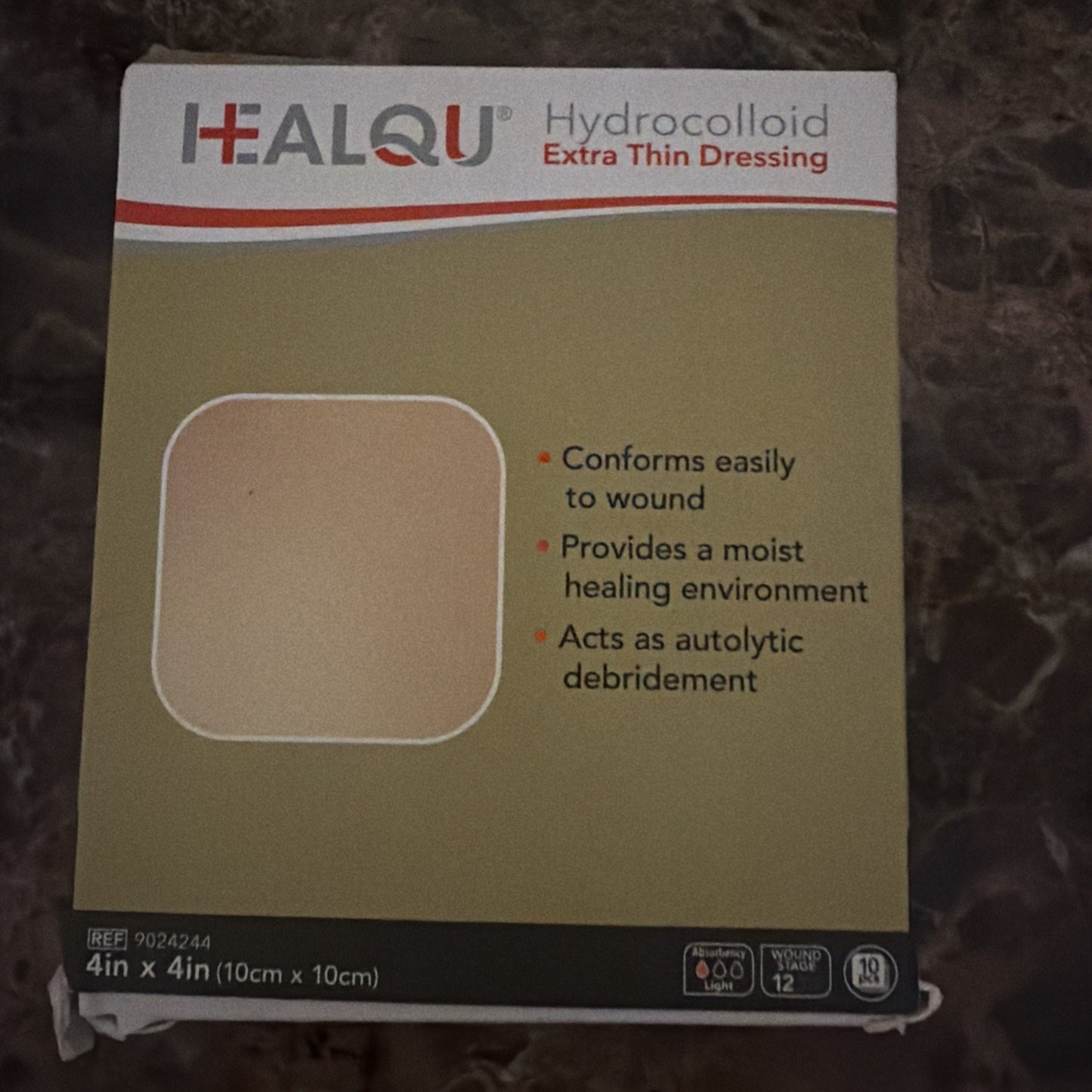 Square-shaped hydrocolloid extra thin dressing displayed on beige packaging highlighting its wound-conforming, moist healing, and autolytic debridement properties.