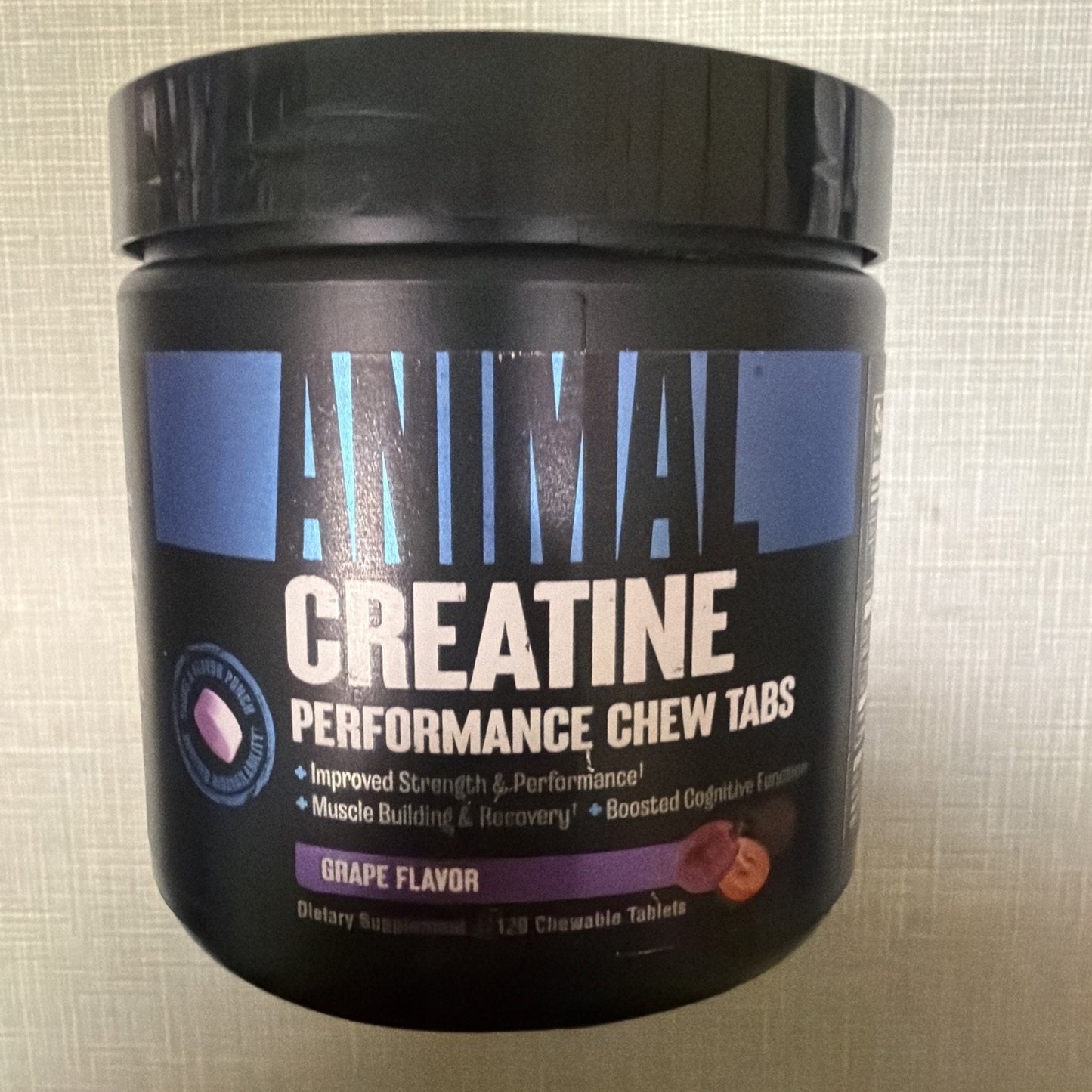 Black container of Animal Creatine Performance Chew Tabs in grape flavor, highlighting benefits like improved strength, muscle recovery, and boosted cognitive function.