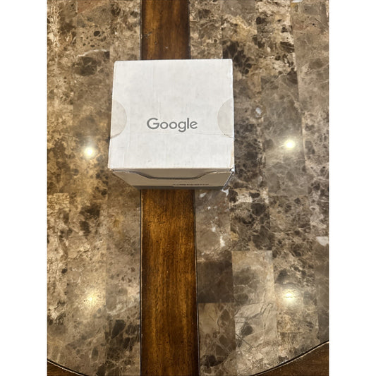 Google Nest WiFi access point box sitting on a glossy brown marble and wood table surface