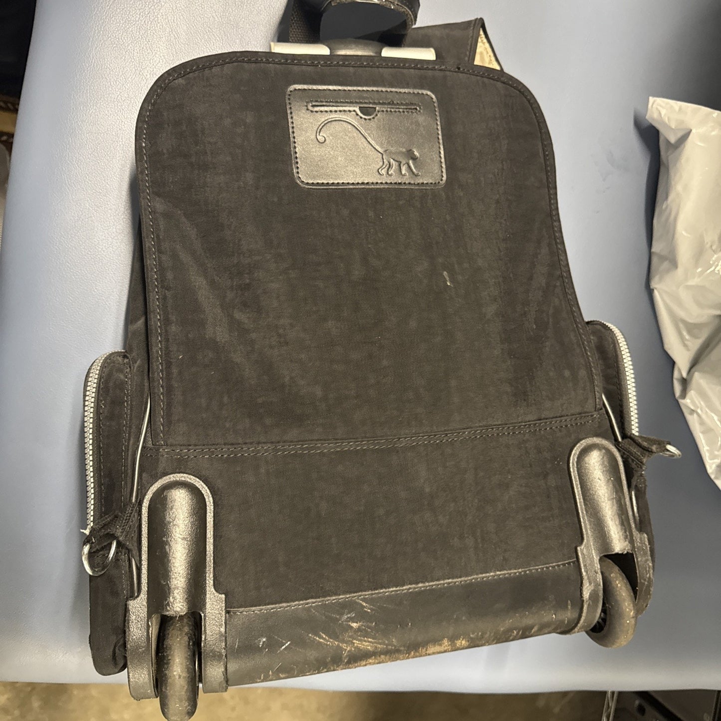 Pre-owned Kipling Gaze large black printed rolling backpack with retractable handle and two wheels visible from bottom view
