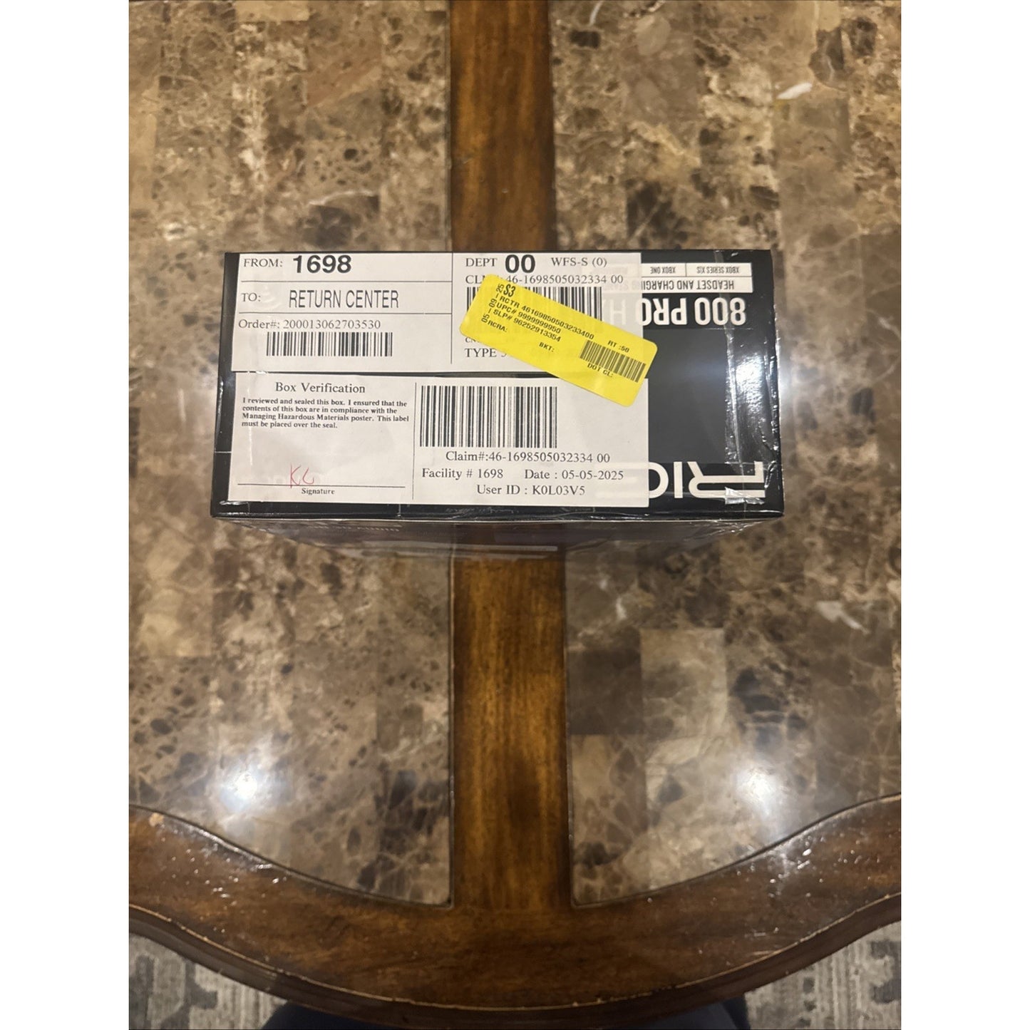 Nacon RIG Wireless Headset and Charging Stand box with shipping labels on marble and wood table background