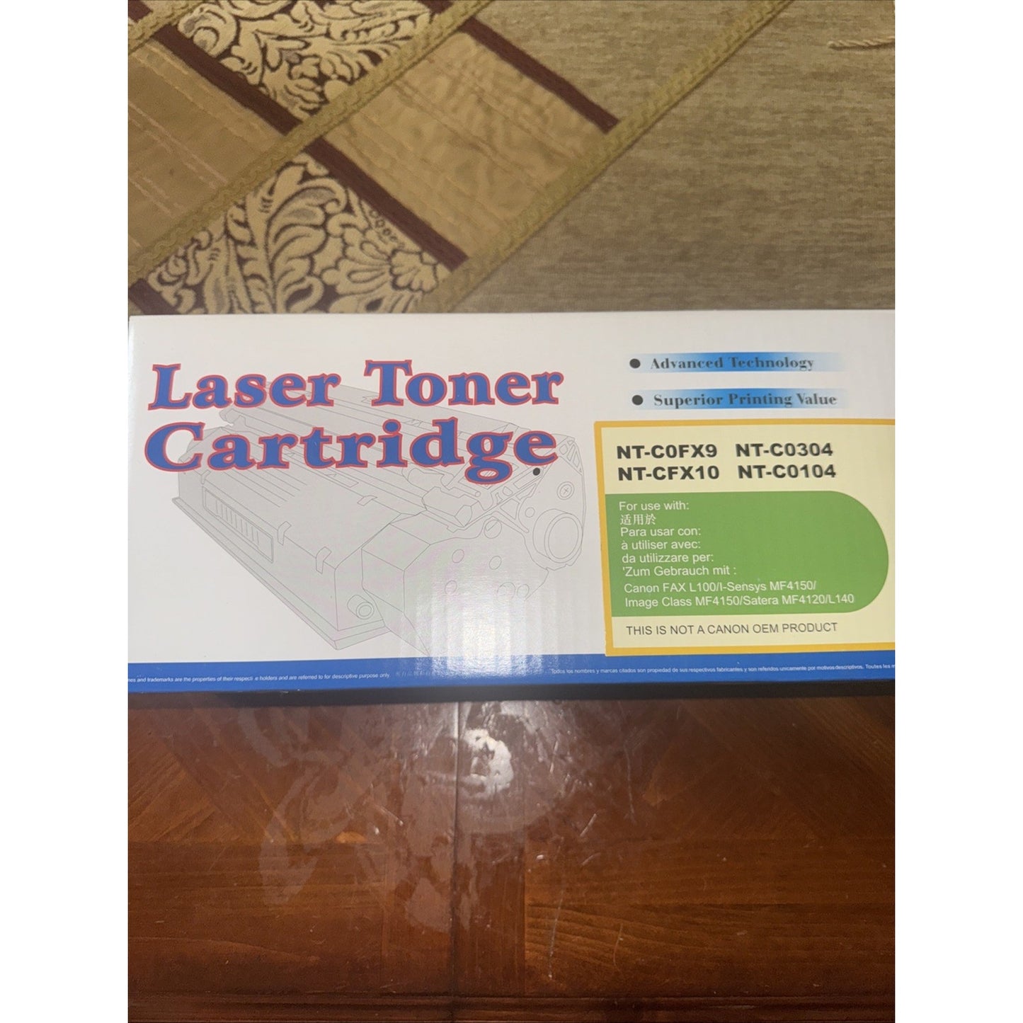 Packaging box of a laser toner cartridge with model numbers NT-C0FX9, NT-C0304, NT-CFX10, and NT-C0104, featuring advanced technology claims and compatibility information on a wooden surface.