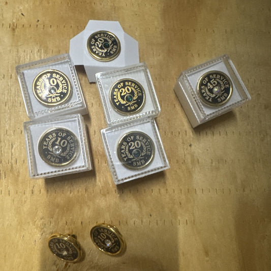 Set of 8 gold tone employee award pins with "10 Year," "20 Year," and "45 Year" inscriptions for years of service recognition