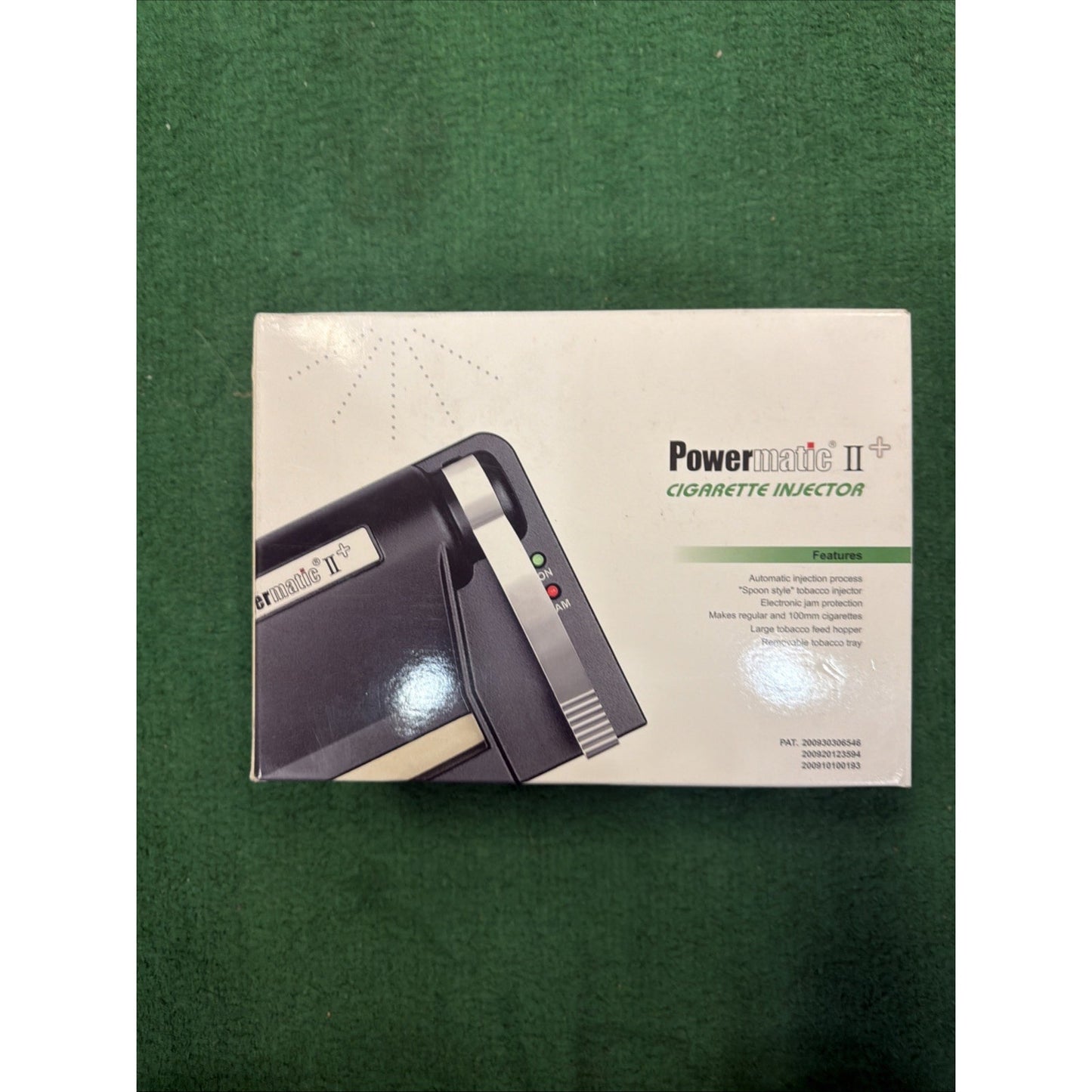 White product box with printed image of a black and beige Powermatic II cigarette injector machine, featuring small colored indicator lights and text listing product features.