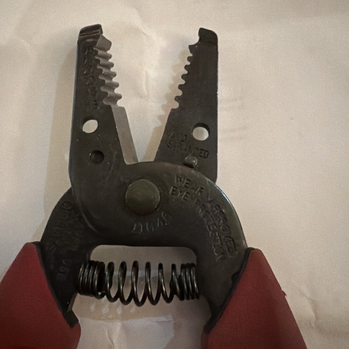 Klein Tools 11046 wire stripper and cutter pliers showing metal jaws and red handles close-up view
