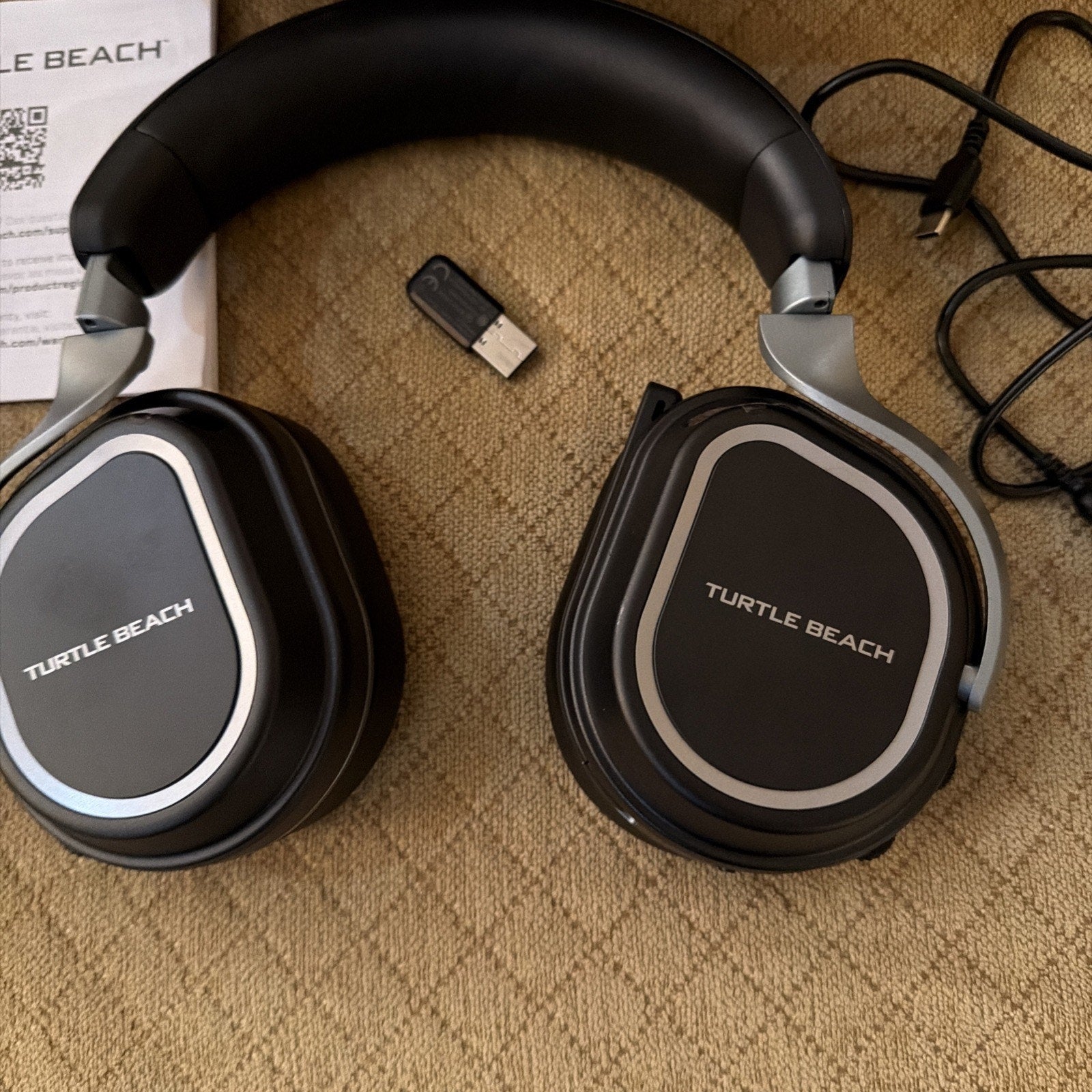 Turtle Beach Stealth 700 Gen 3 wireless gaming headset black with USB dongle and charging cable on beige background