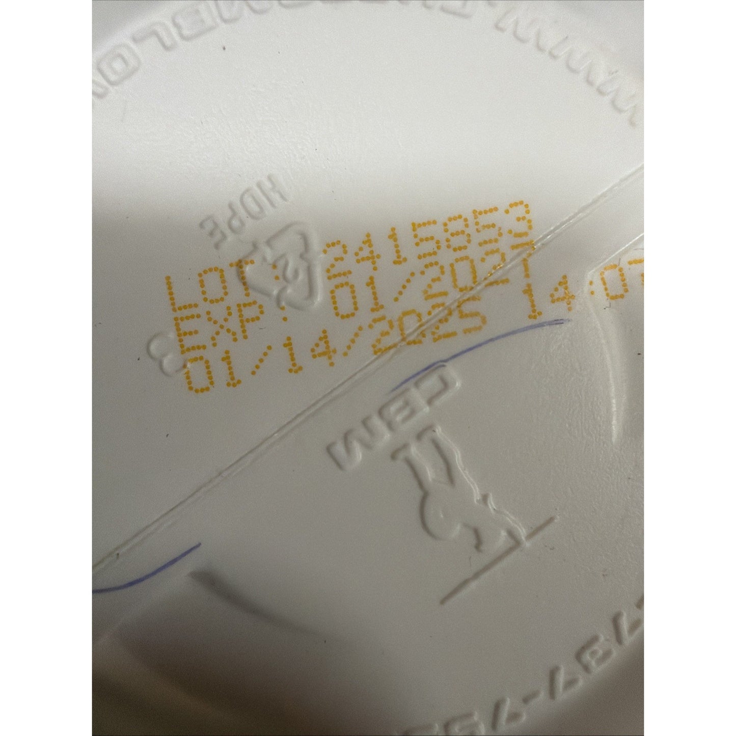 Close-up of a white plastic container lid showing a yellow printed lot number 2415853, expiration date 01/2025, and embossed recycling and material symbols.