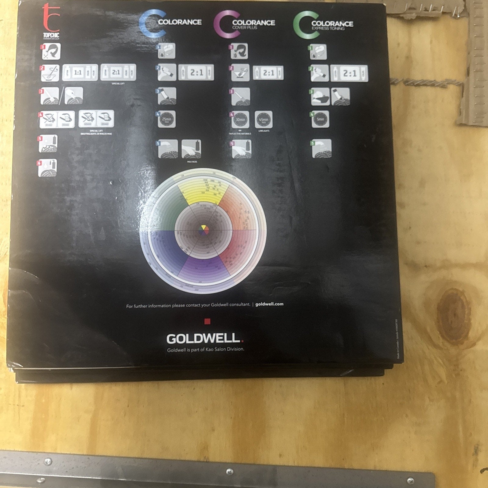 Goldwell Color Catalog showing color mixing ratios and a circular color wheel on a black background guide