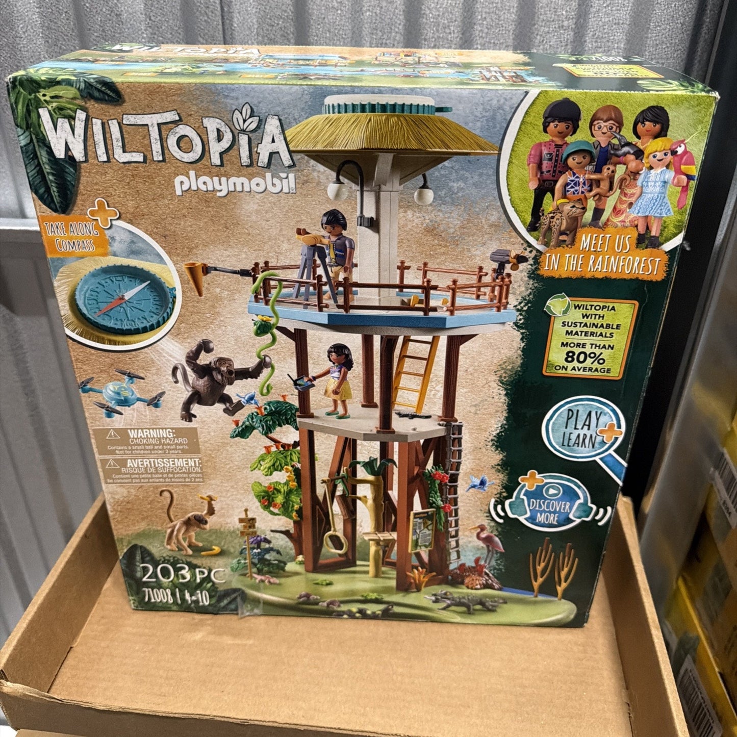 Playmobil Wiltopia rainforest lookout tower playset with multiple human figurines, jungle animals, ropes, trees, and educational features promoting sustainability and wildlife exploration.