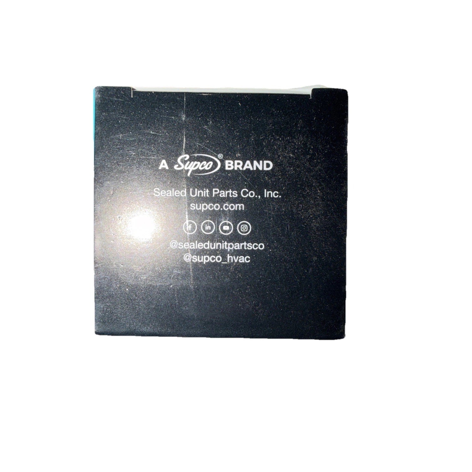 Black square box displaying white printed branding and contact information for Supco with social media icons and website details on a light background.