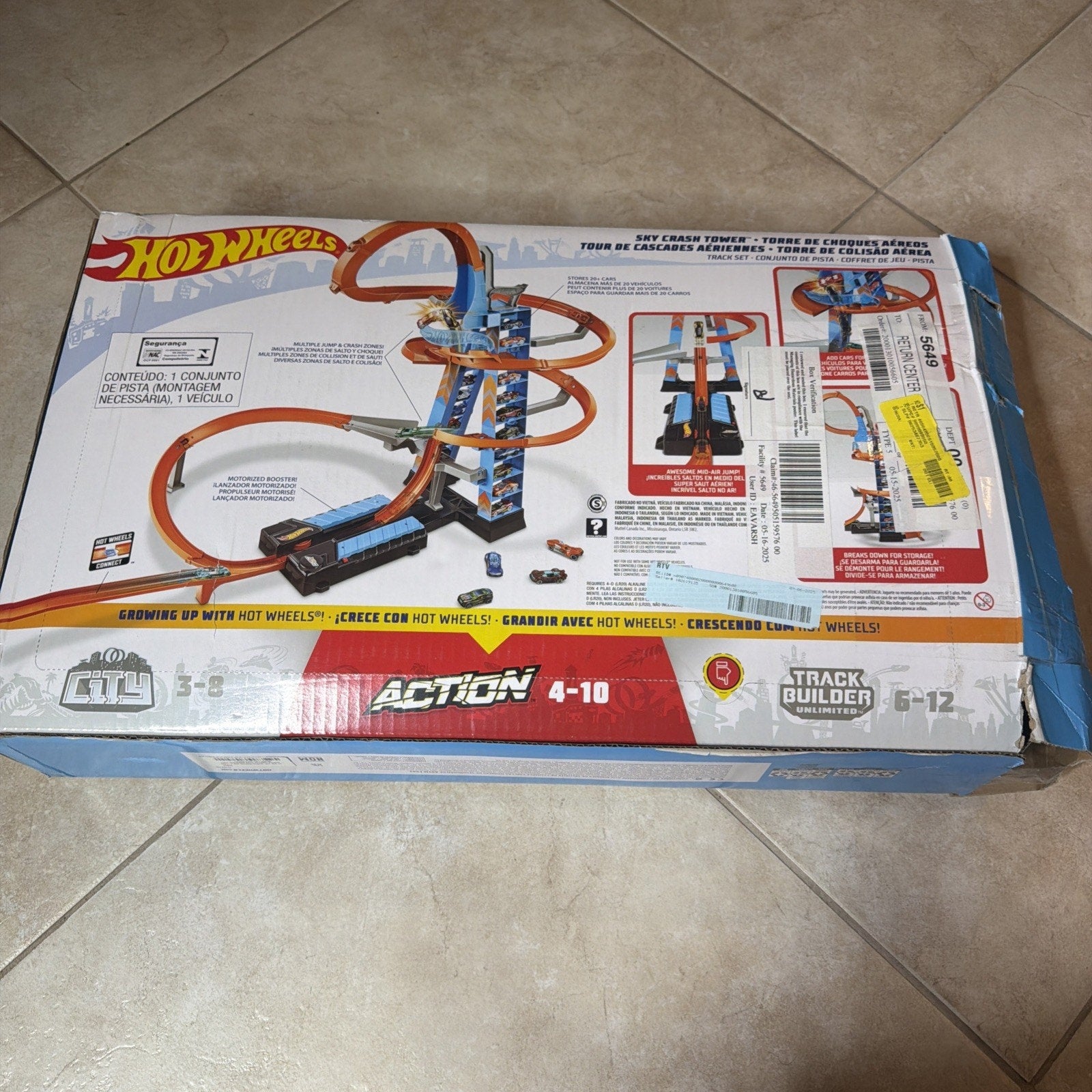 Box showing a Hot Wheels Sky Crash Tower playset with an orange and blue twisted race track featuring loops and drops, designed for children aged 4 to 10, with instructional diagrams and product information on the packaging.