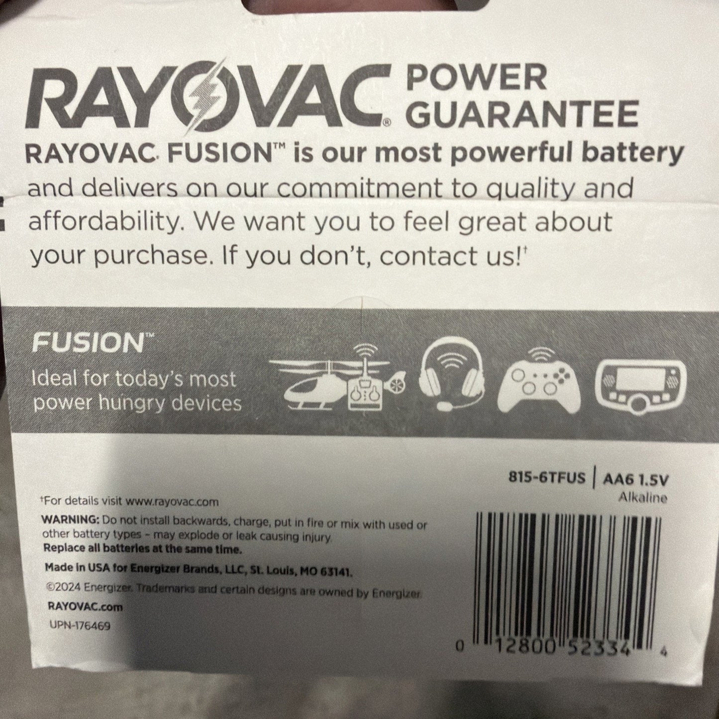 Packaging label for Rayovac Fusion alkaline AA batteries highlighting power guarantee, suitability for high-drain devices, barcode, and safety warnings on a white background.