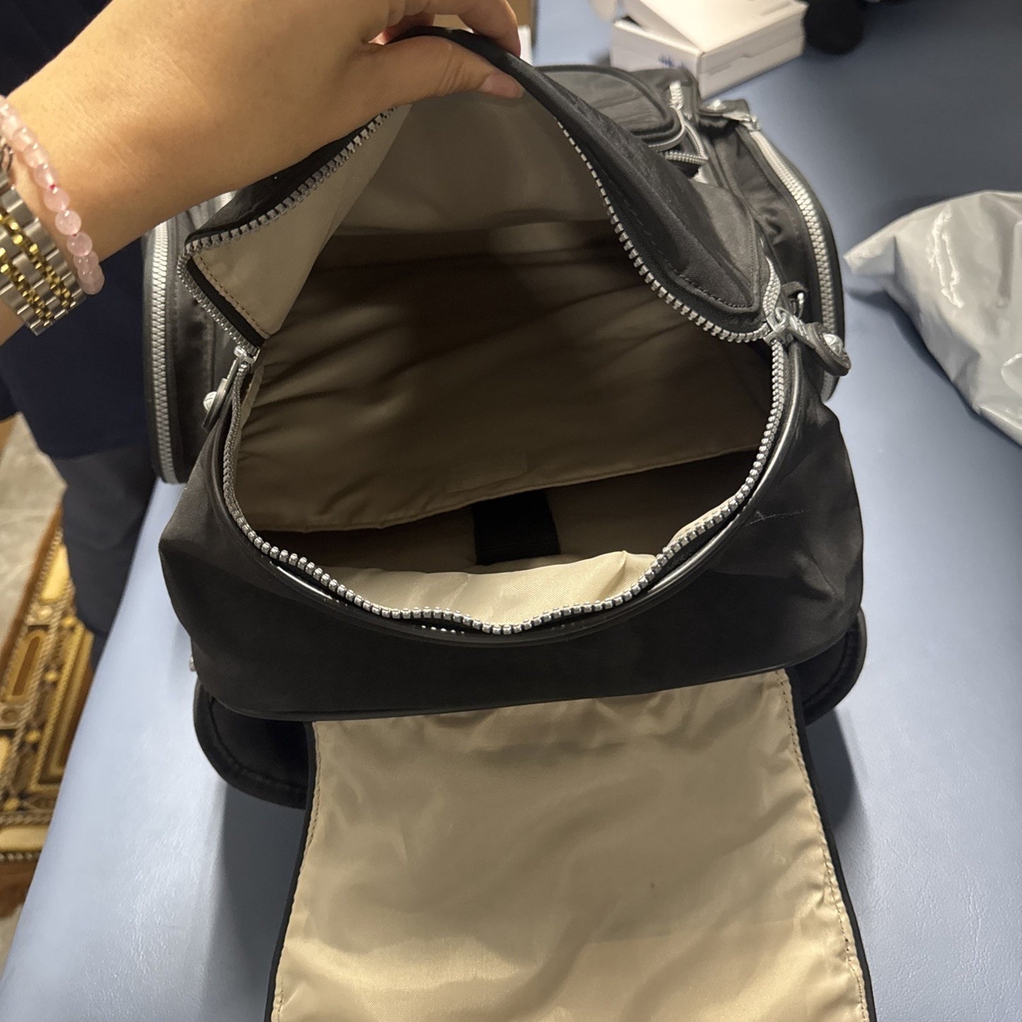 Open Kipling Gaze large printed rolling backpack showing beige interior compartment with zipper closure and front flap